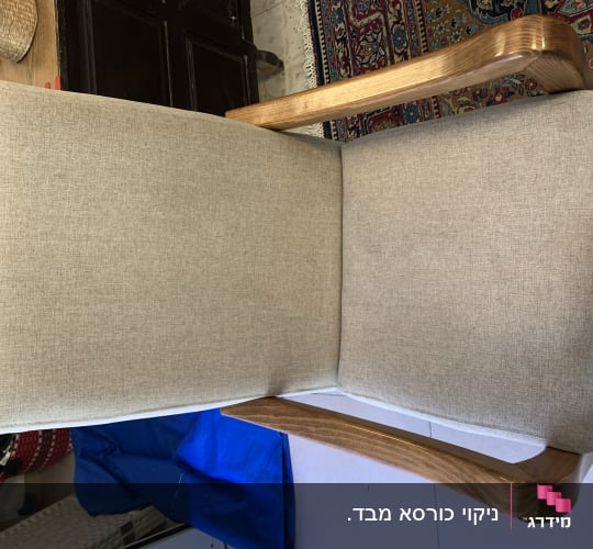 כיסא עם ריפוד בד בהיר וידיות עץ